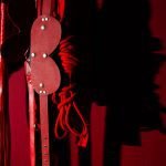 Swingers Club - close-up-sex-toys-hanging-against-wall