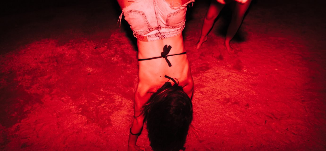Swingers Club - Group of young women having fun at a lakeside party at night with a red light
