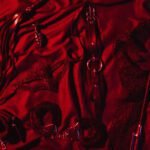 Erotic sex toys for adults for BDSM sex with submission and domination. Handcuffs, mask and leather flogger whip on a black background