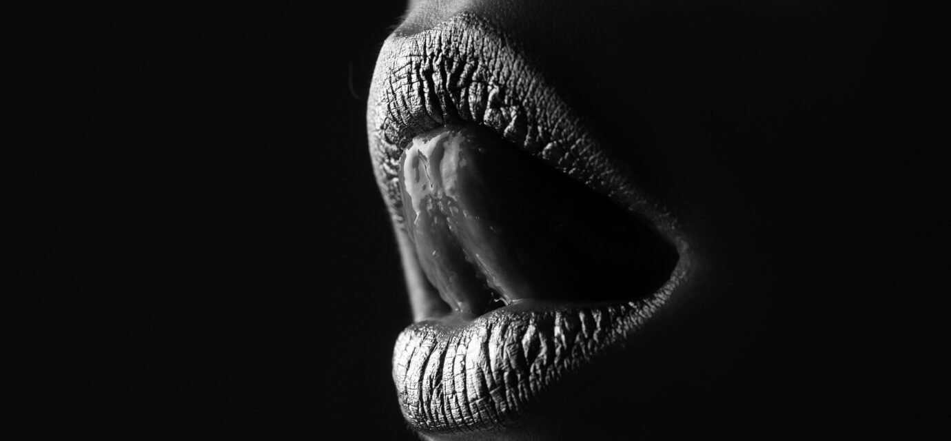 Gold lips. Woman wouth close up with golden color lipstick on lip. Glitter glossy lips biting.